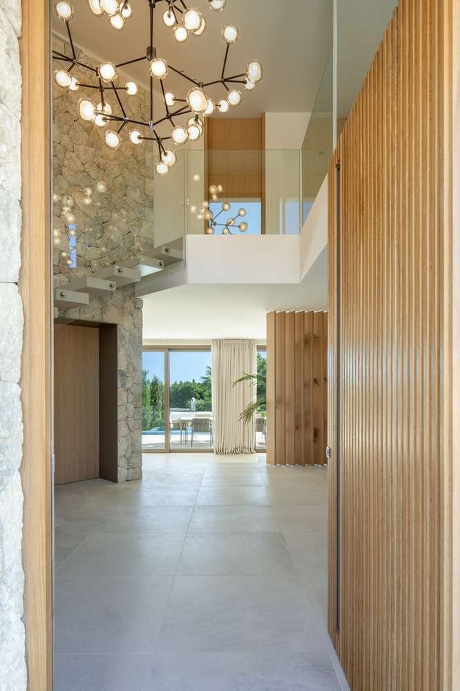 Double-height entrance hall with natural stone and timber